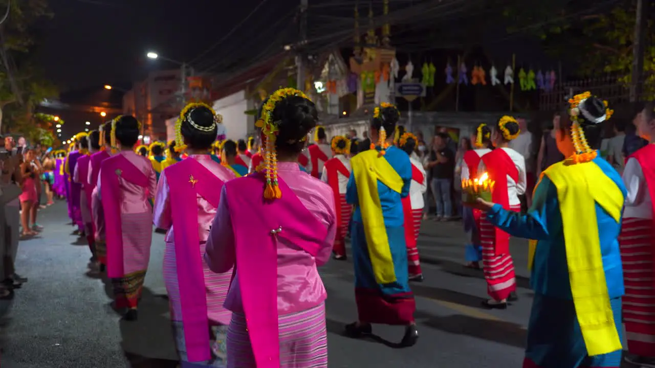 Slow pan across women walking during traditional Yi Peng Festival in Thailand