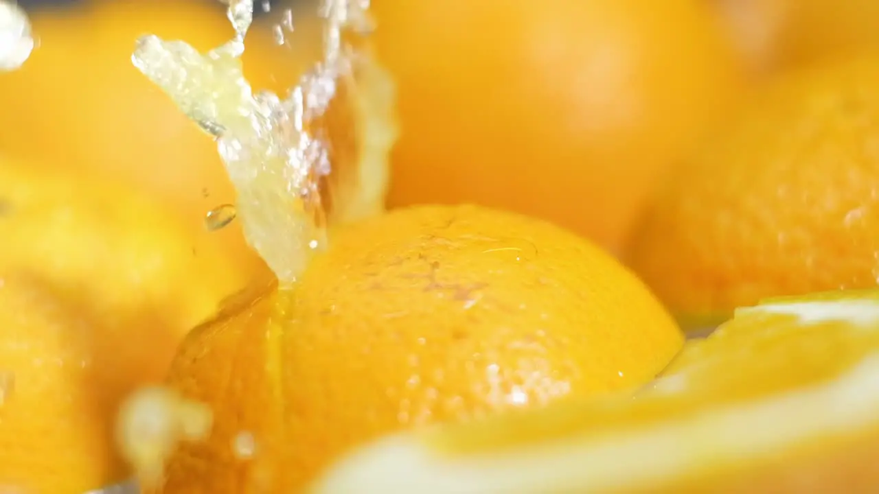 Juice explosion through half sliced Orange fruit in Slow motion