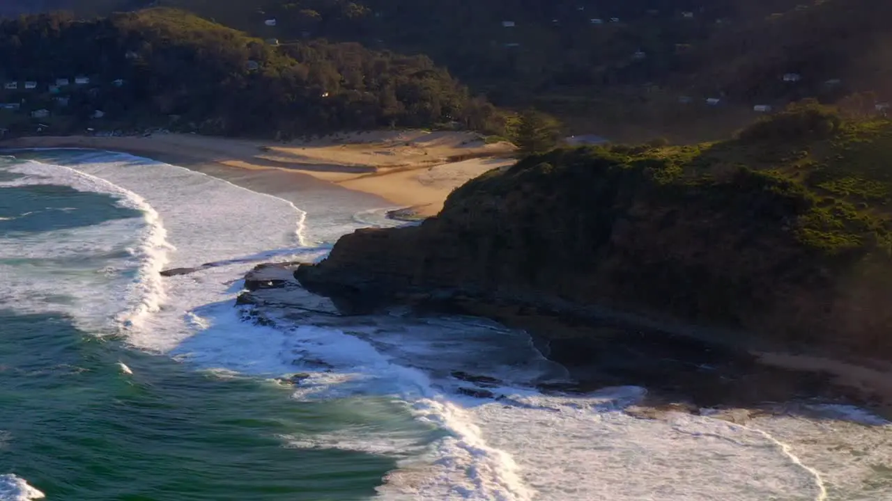 Frothy Waves Rolling Towards Era Foreshore With Cottages On Lush Plateau In Royal National Park NSW Australia