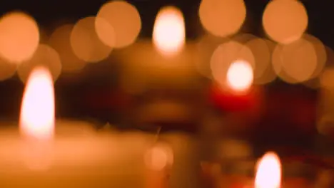 Defocused Shot Of Romantic Red And White Candles With Bokeh Lighting On Black Background