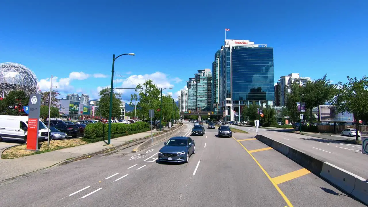 Vehicles drive by science museum Science World in Vancouver slow motion