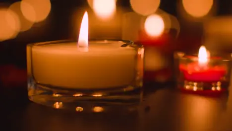 Close Up Of Romantic Lit Red And White Candles Burning On Black Background With Bokeh Lighting 2