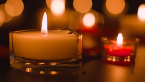 Close Up Of Romantic Lit Red And White Candles Burning On Black Background With Bokeh Lighting 1