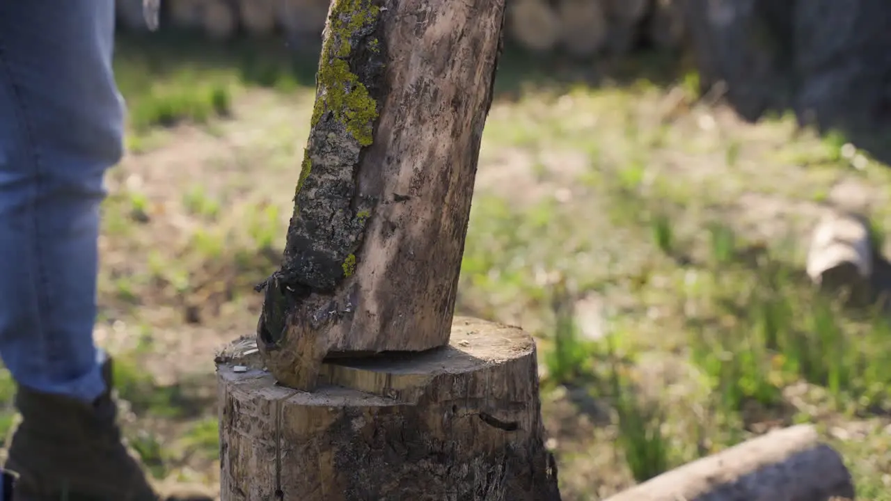 Close-up view of unrecognizable man chopping firewood with an ax outside a country house