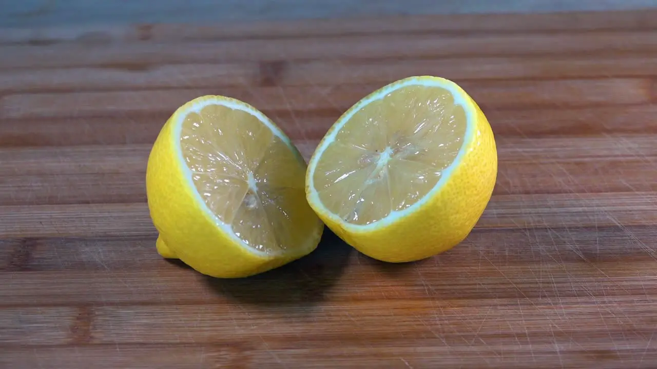 Slider Shot of Sliced Lemon Halves on a Wooden Chopping Board in the Kitchen