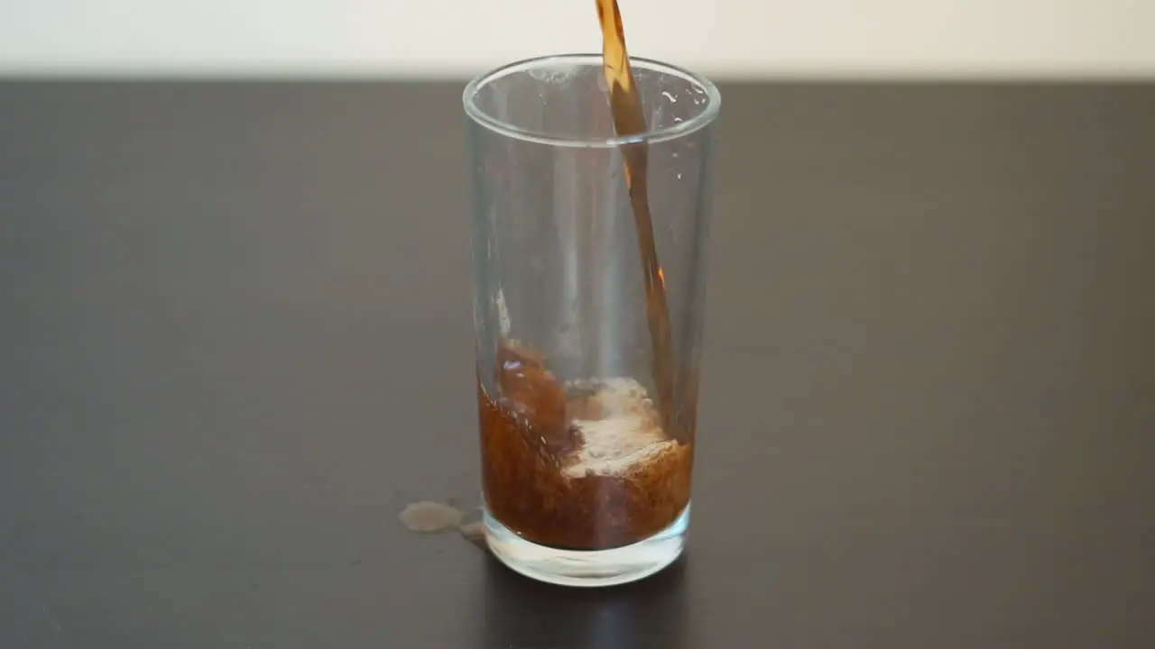 Slow motion man pouring soda into a glass