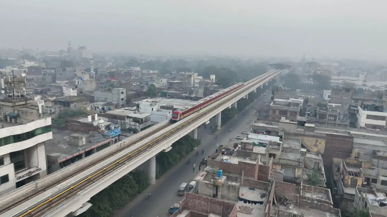 Aerial View Of Orange Line Metro Train Near McLeod Road In Lahore On Elevated Track With Hazy Air Pollution In Background