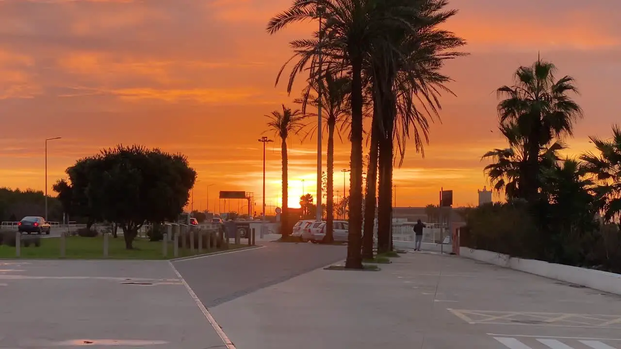 High contrast silhouettes of beach parking on horizon with beautiful deep sunset colours light and cloudy sky Praia de Carcavelos Portugal