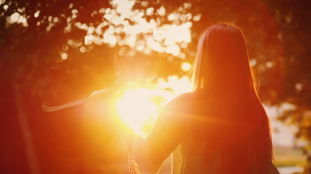 A Child Plays A Plane At Sunset Silhouette Of A Girl In The Rays Of The Orange Sun