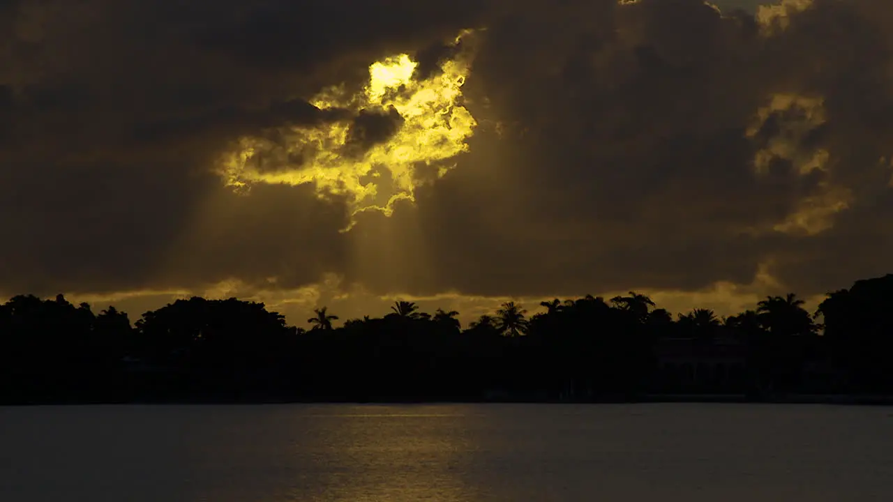 Golden Sun Streams Down From Hole In Clouds Onto Water In South Florida Early Morning