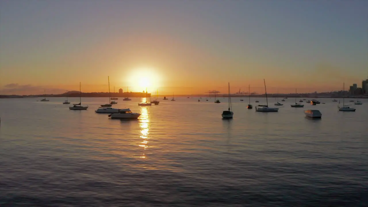 Sunset illuminating boats that are anchored in marina at evening dusk time