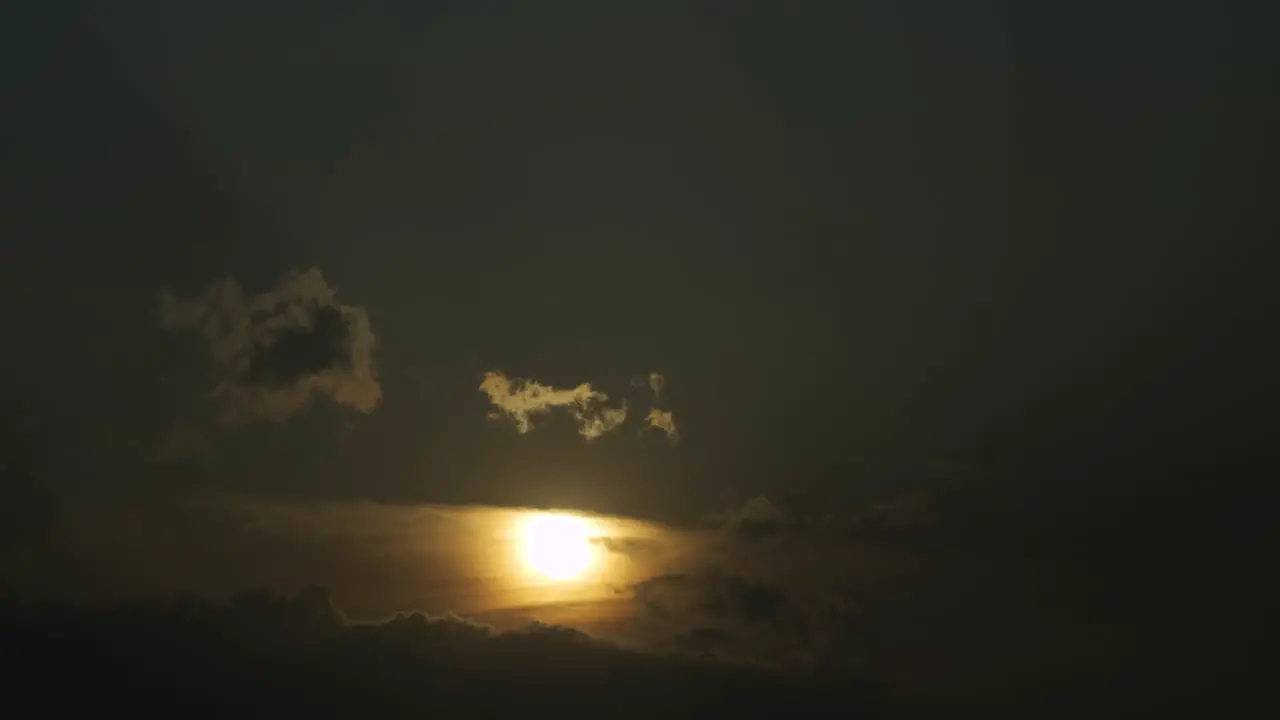 The beautiful yellow sun setting behind the clouds time lapse