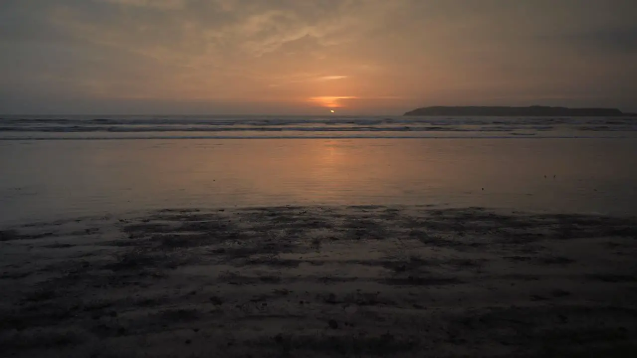 Young woman with untied bouncing let down hair running at the beach with dumbbells in her hands at dusk