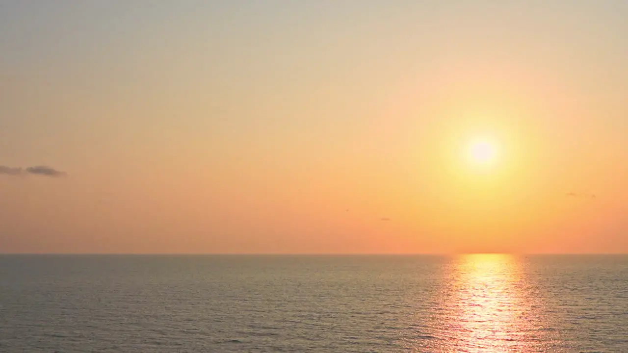 Endless seascape on Red and Pink Colorful Seaside Sunset with sunlight reflection in the water surface in Bali Indonesia