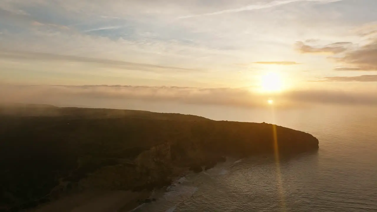 Silhouetted coastline against sunset sky