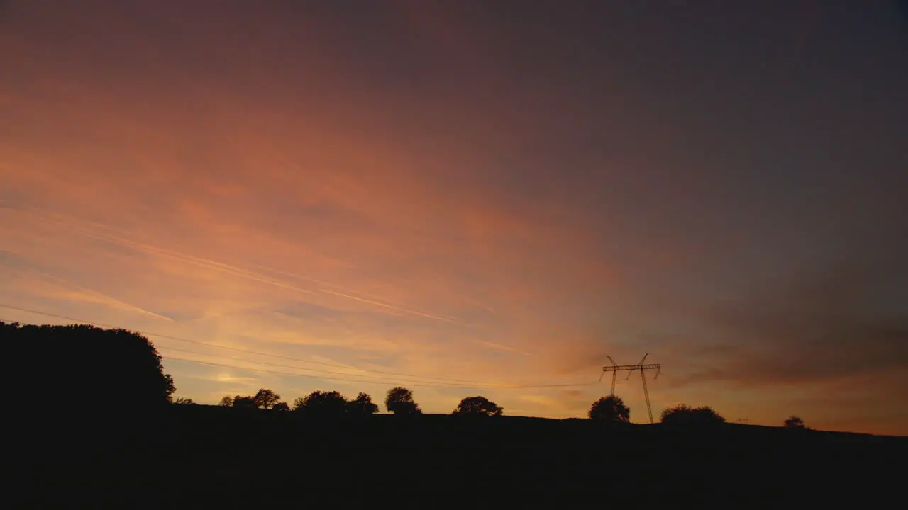 Beautiful real time shot of a sunset sky with an electric pylon