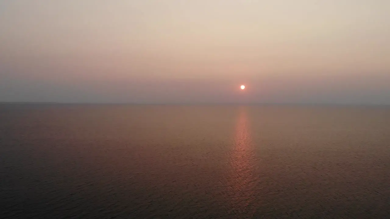 A fly through drone shot passing between two pine trees capturing the gorgeous sunset on a cool summer night at Ellison Bluff State Park in Door County Wisconsin