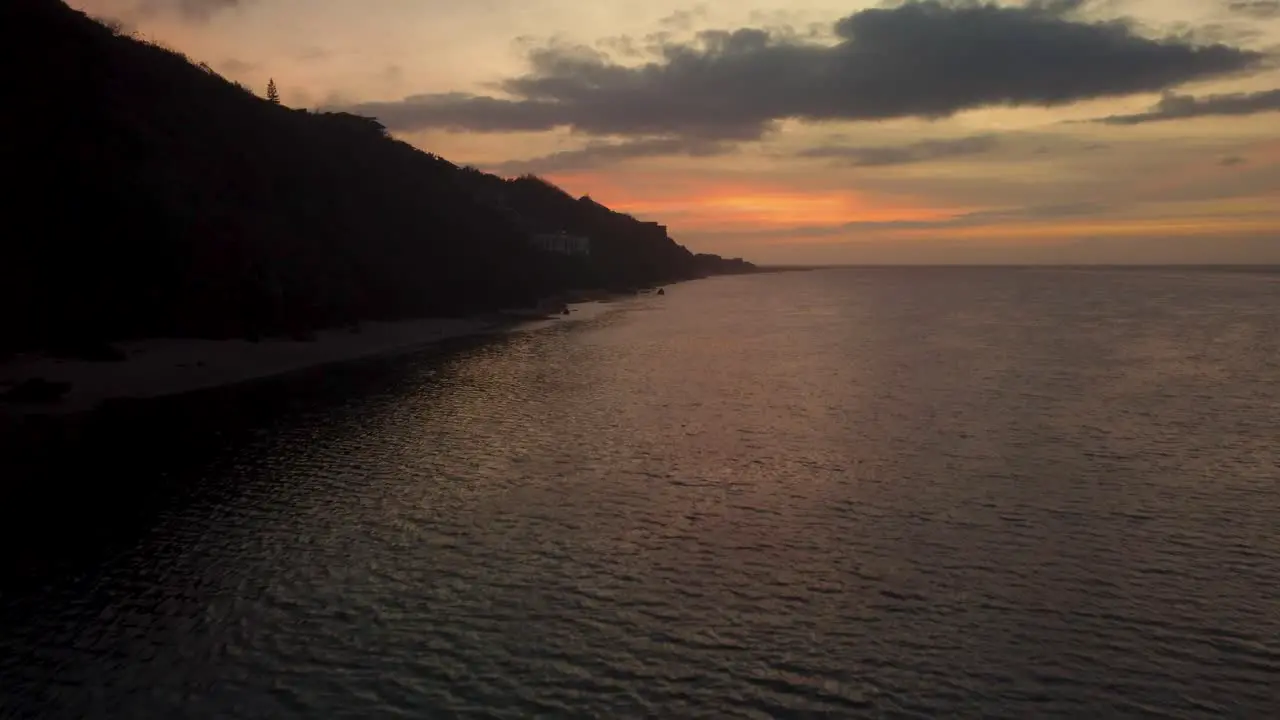 AERIAL Drone shot over the ocean showing a beautiful sunrise