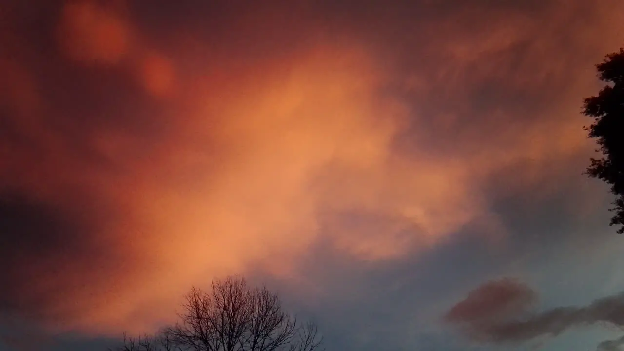 Pan across orange and red storm clouds at sunset