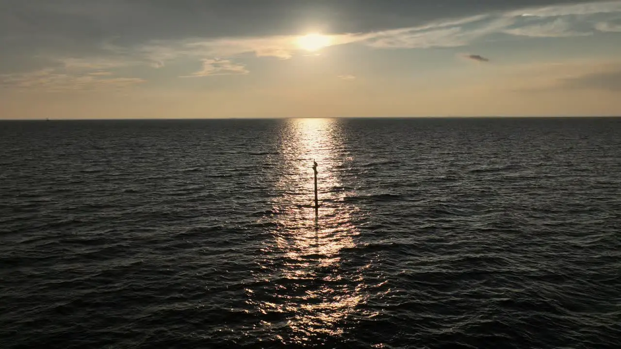 Sunsetting in Mobile Bay as a Pelican watches perched on a pole