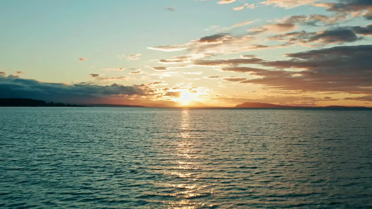 Aerial Fly Over of Beautiful Sunset Over Water Calm and Relaxing Golden Hour Background