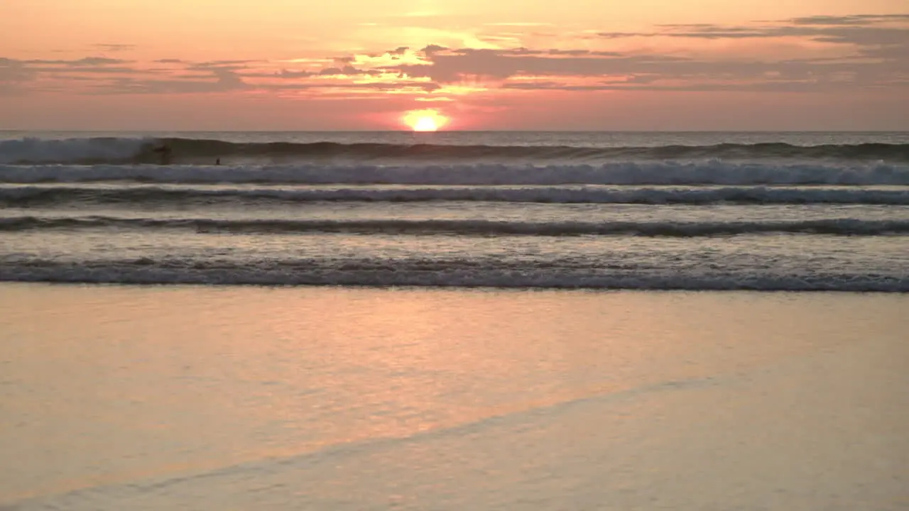 Bodyboarders in the ocean surfing at sunset