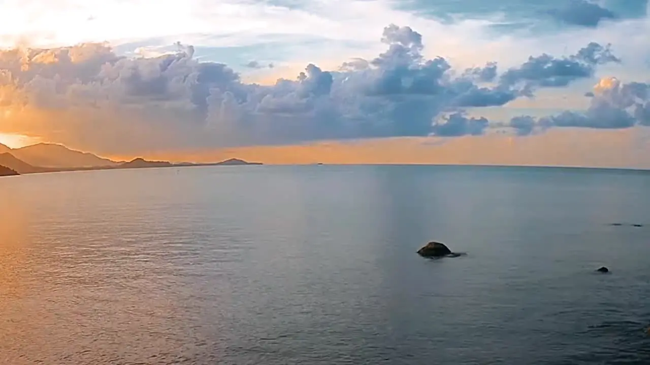 Peaceful ocean on a sunny day with clouds over the water