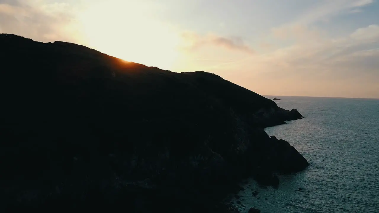 Drone Shot Aerial sunset over mountain silhouette at sea bay in France Brittany