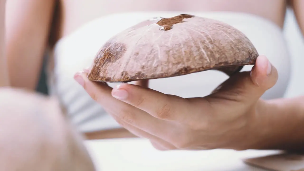 Close up of a woman crafting coconut shells on balcony at home