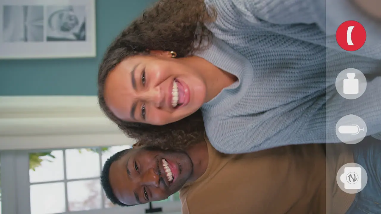 Vertical Video Showing Device Screen With Icons As Young Couple Make Video Call