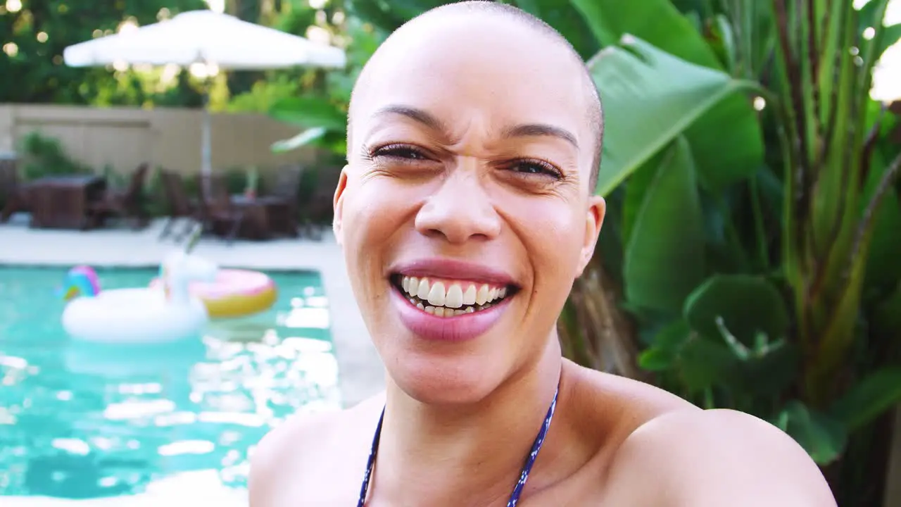 Portrait Of African American Woman With Shaved Head Outdoors With Friends Enjoying Summer Pool Party