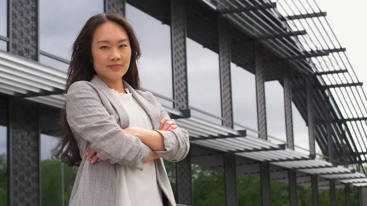 Portrait Of Serious Businesswoman Standing Outside Modern Office Building