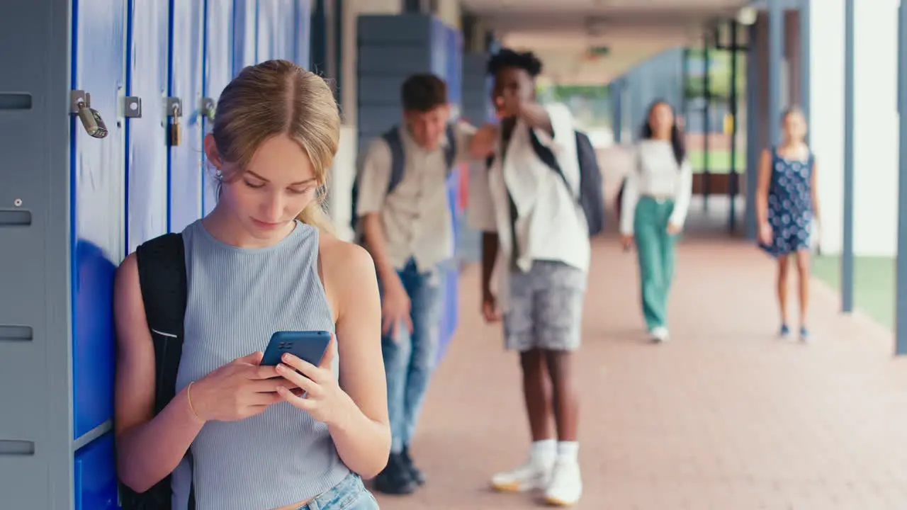 Unhappy Female High School Or Secondary Student Being Teased And Bullied By Boys Outdoor Lockers