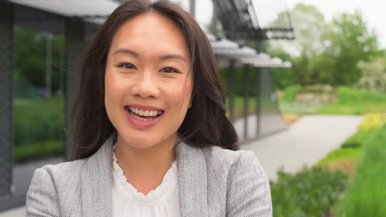 Portrait Of Smiling Businesswoman Standing Outside Modern Office Building