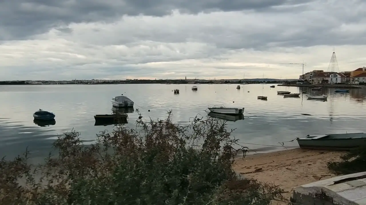 Boats Moored At An Urban Beach In Portugal On A Cloudy Sunset dolly shot