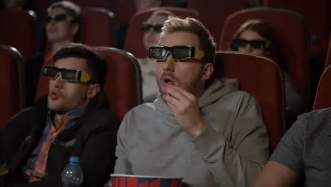 People in 3d glasses at cinema Man in 3d glasses eat pop corn