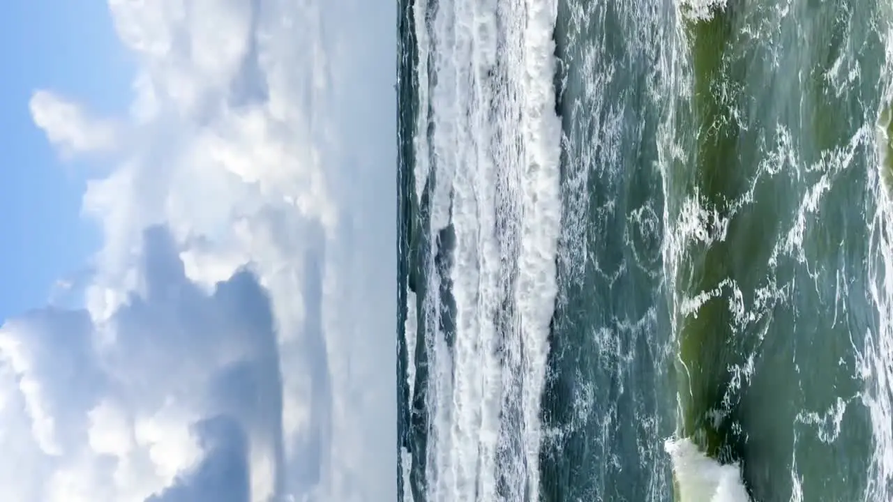 Dynamic Majesty Powerful Sea Waves Crashing on Palanga Shoreline Lithuania Against a Backdrop of Blue Skies and Clouds