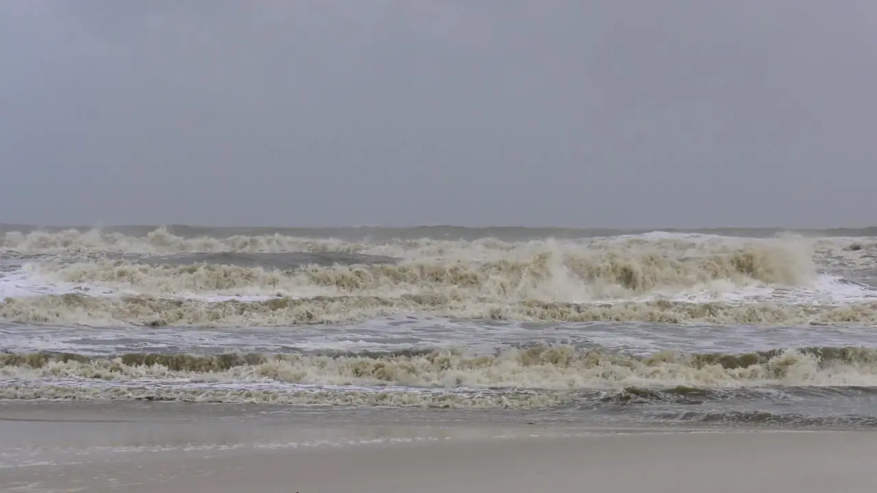 Violent ocean waves during a tropical storm crash towards a beach