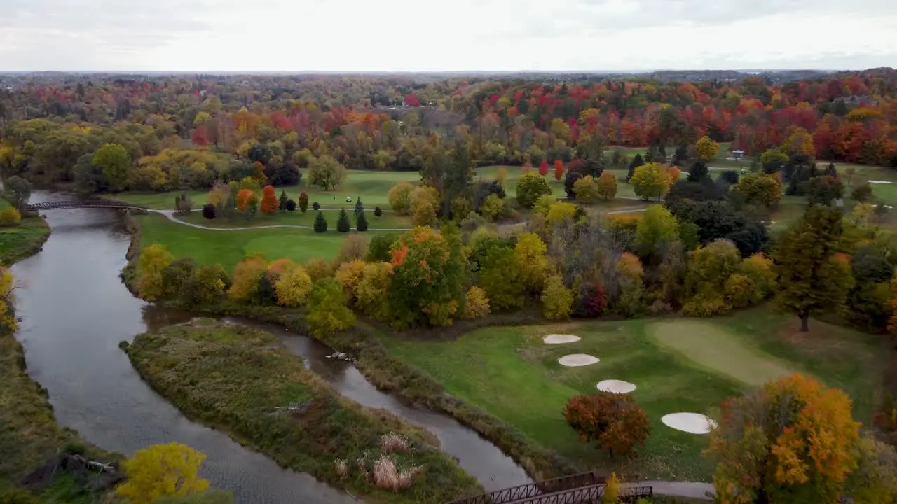 Fly over a river in a park in a fall cloudy moody day