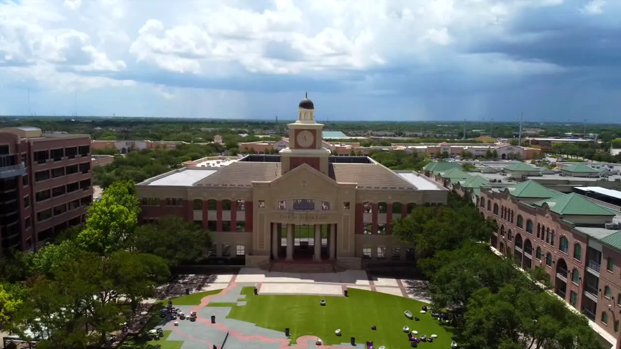 An aerial shot of Sugar Land's Towne Hall Building on a partly cloudy day at 60 frames