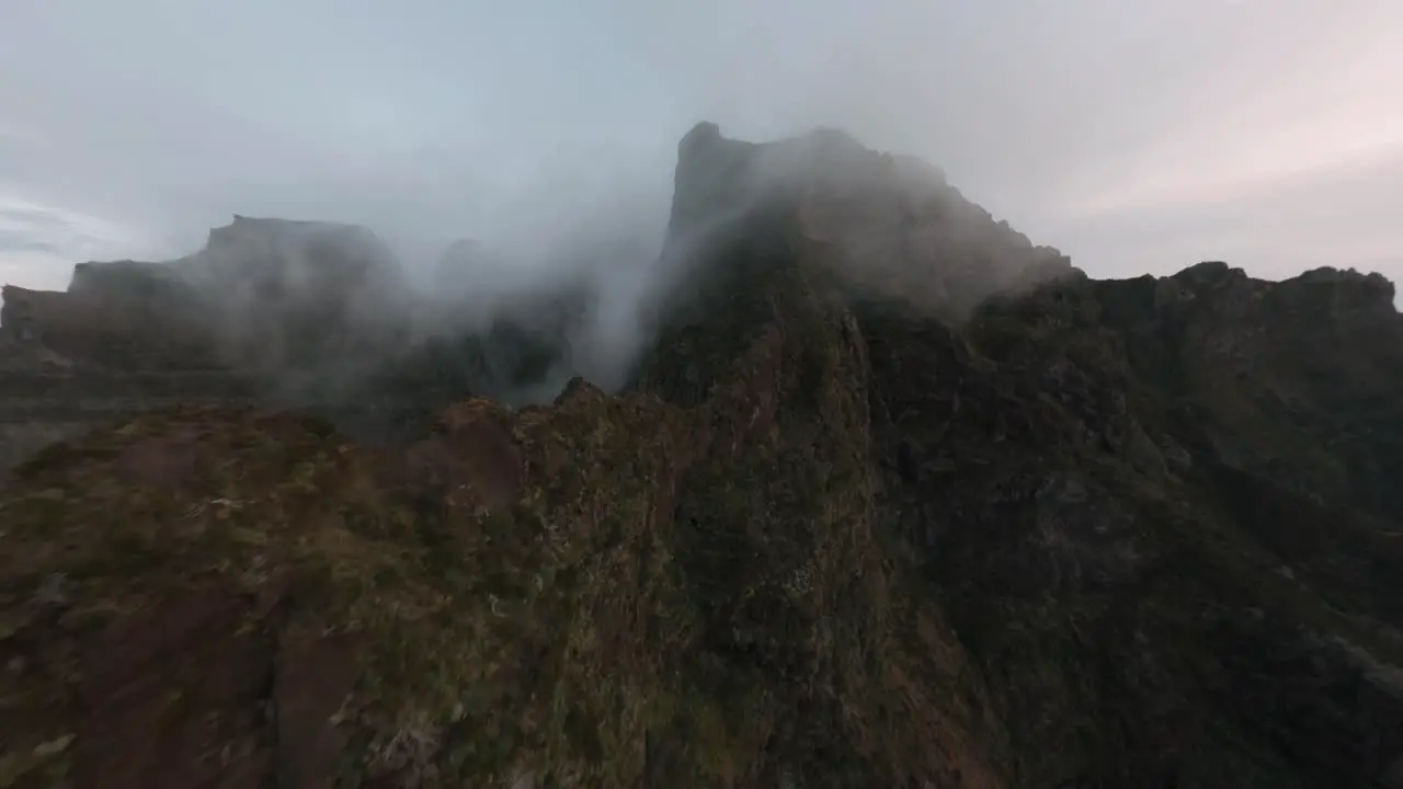 FPV drone flying in the mountains through fog over the clouds at Madeira island