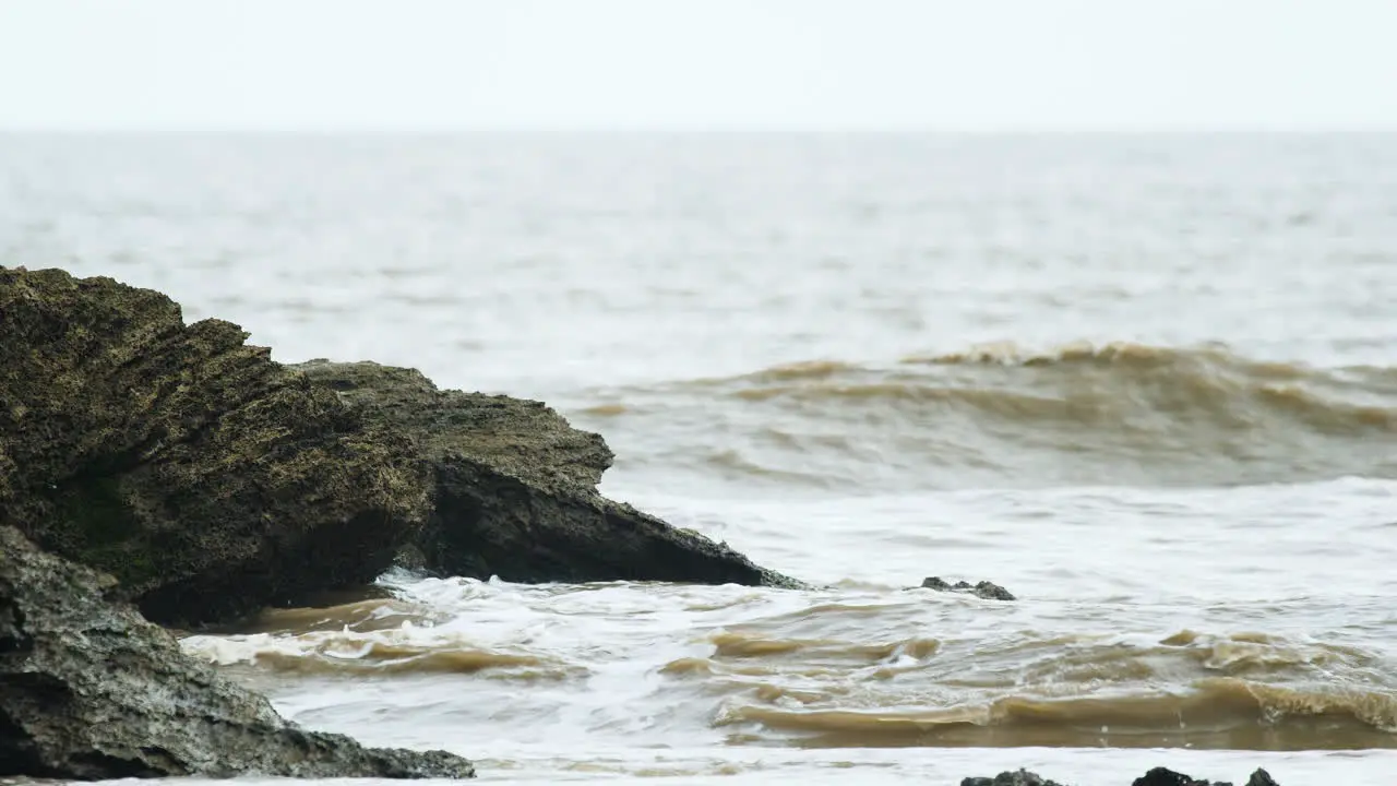 Waves crash on the Rock in the sea during the beginning of the high tide in the Arabian Sea on a evening