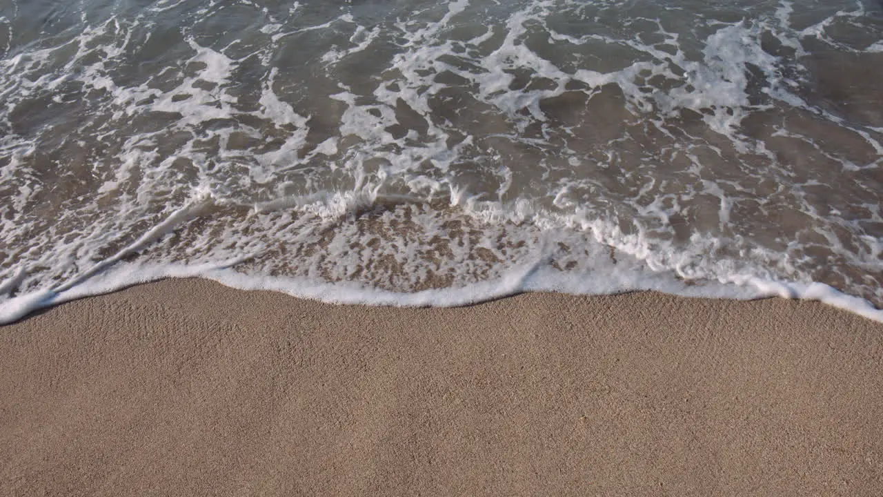 Small waves Lapping against Sandy beach Sun Glistening on Surface on Sunny Day Waikiki Hawaii