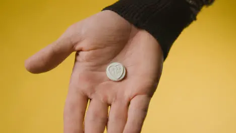 Close Up Of Hand Holding Heart Candy With Miss You Message On Yellow Background