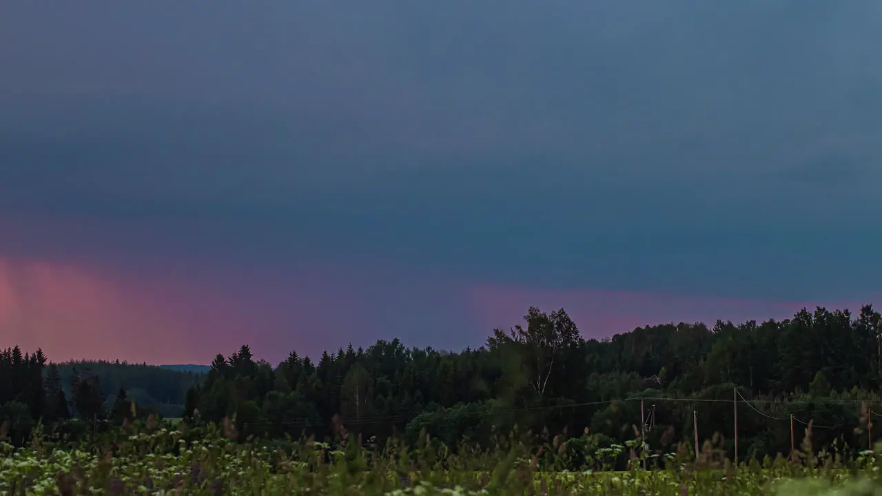 A dramatic lightning and thunderstorm in the dark sky over the forest time lapse