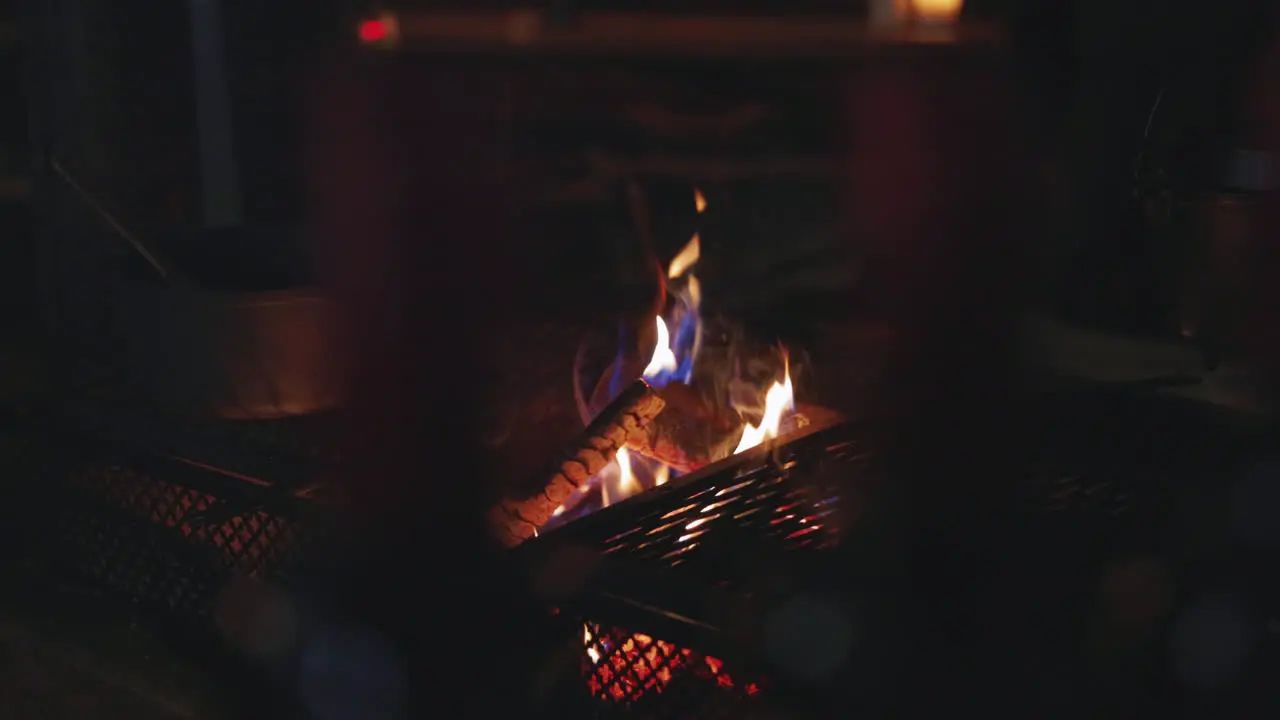 Cosy barbecue fire pit with flaming logs burning at night