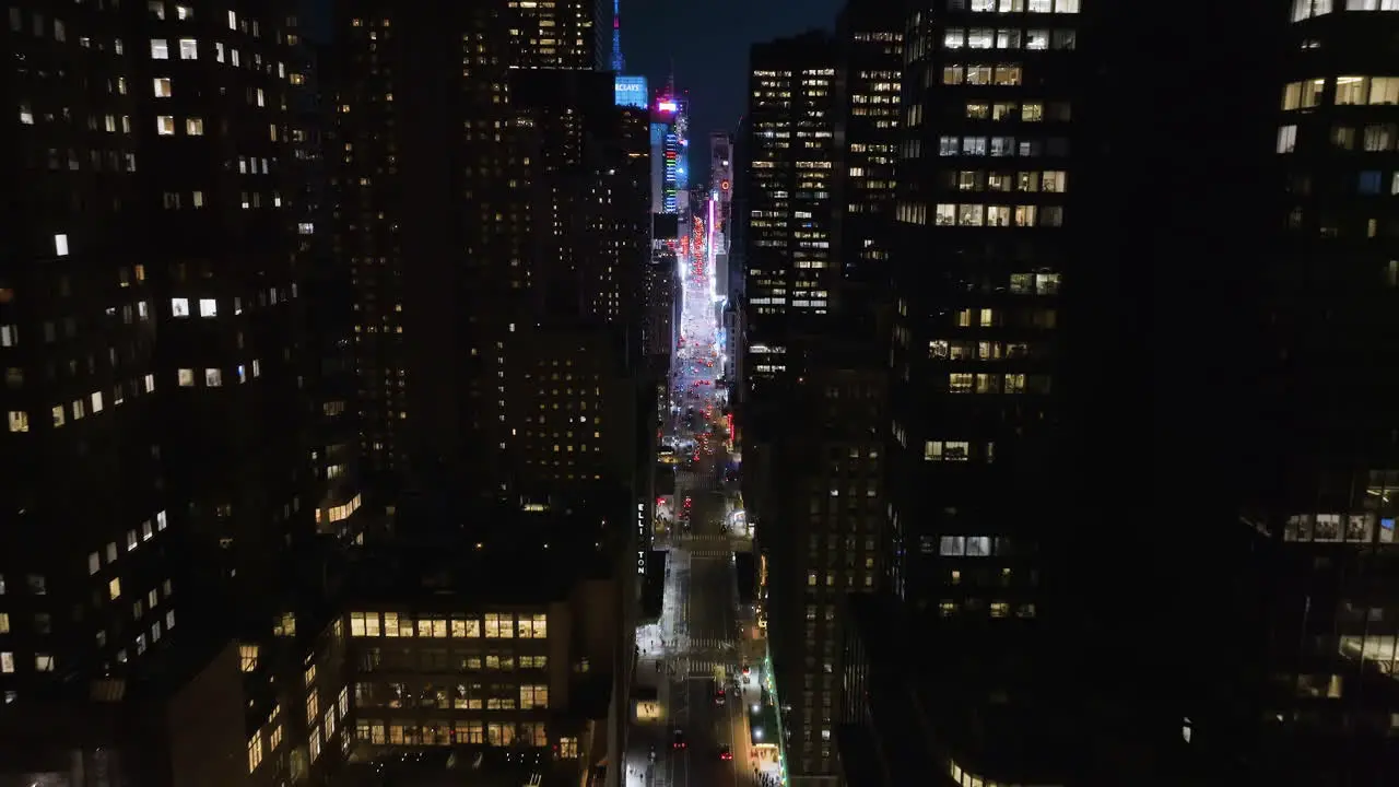 Drone shot tilting over the 7th ave through the illuminated midtown to Times square NY