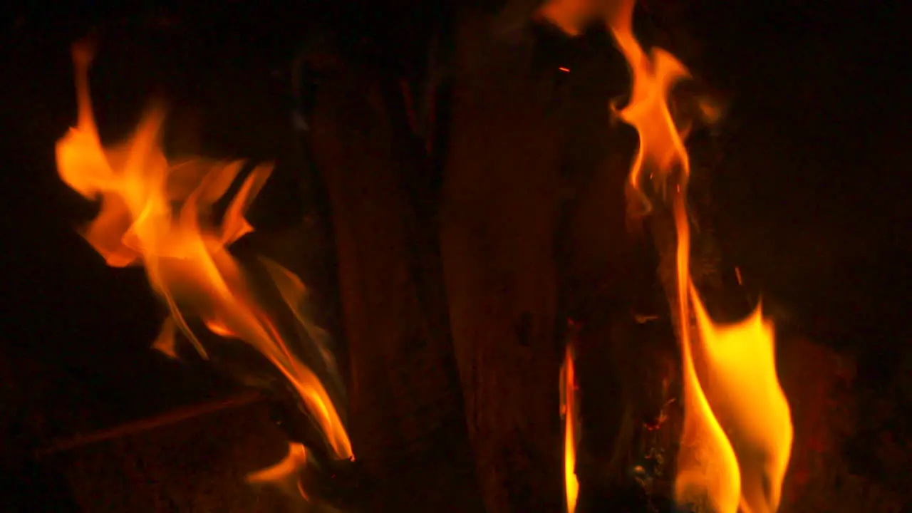 Slow motion close up flames burning around a log in a fireplace