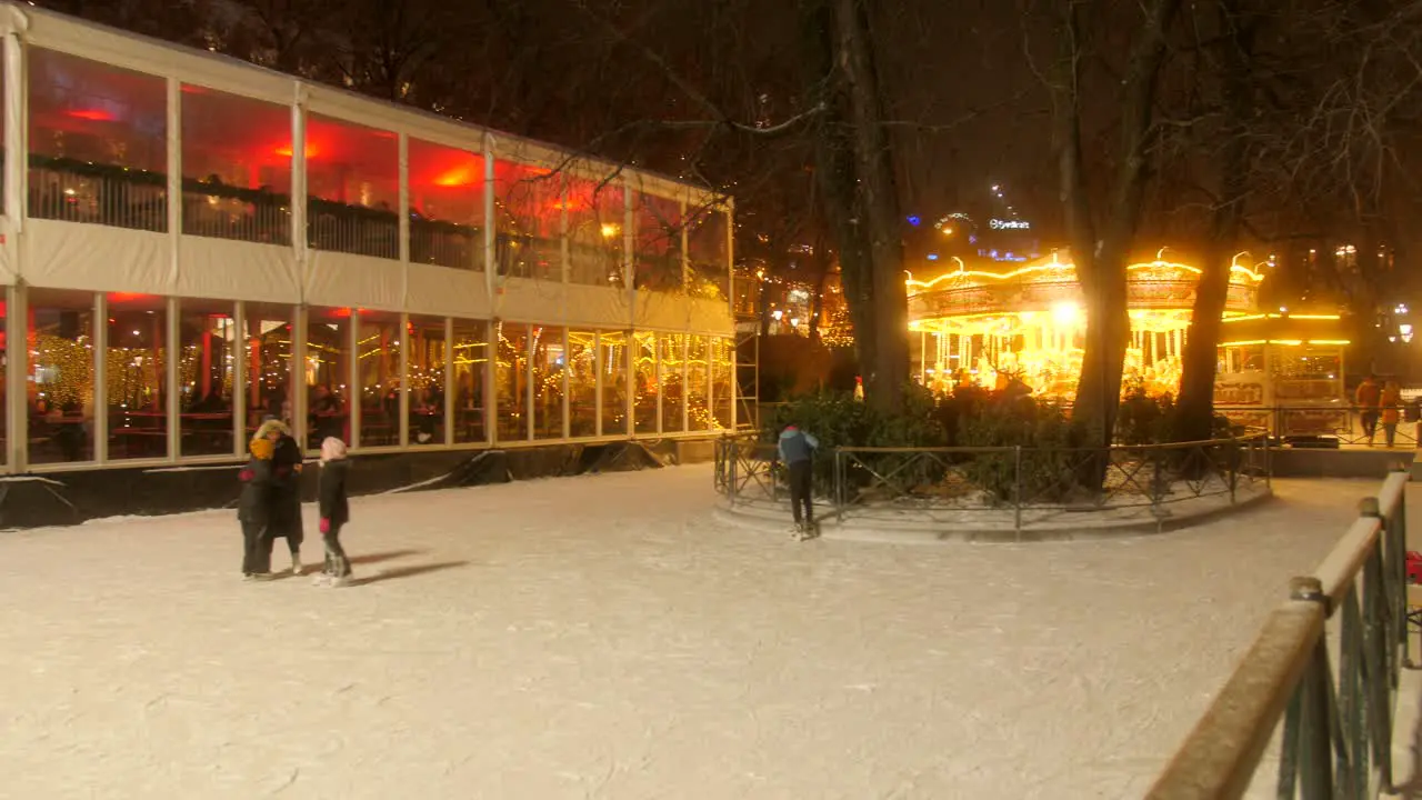 People Having Fun On Skating At The Ice Rink During Christmas Holiday On A Cold Night In Oslo Norway