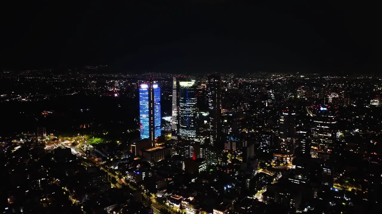 Aerial view approaching the illuminated Reforma skyscrapers in downtown of CDMX